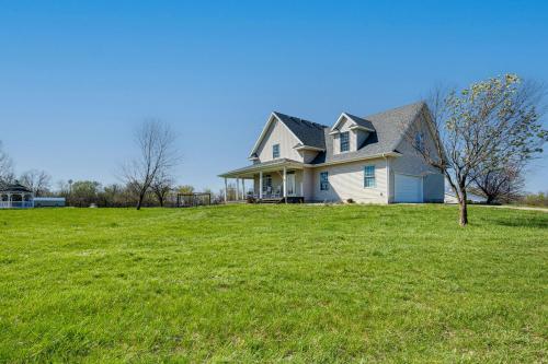 a house on a hill with a green lawn at Fire Pit and Gazebo Rural Warrensburg Getaway! in Warrensburg