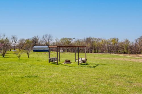 a park with two benches in a green field at Fire Pit and Gazebo Rural Warrensburg Getaway! in Warrensburg