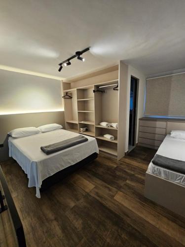 a large bedroom with two beds and a closet at Lofts 4 Elementos - Terra - Martim de Sá - Caraguatatuba in Caraguatatuba