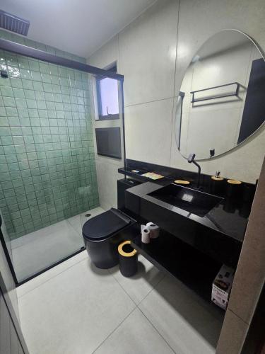 a bathroom with a toilet and a sink and a mirror at Lofts 4 Elementos - Terra - Martim de Sá - Caraguatatuba in Caraguatatuba