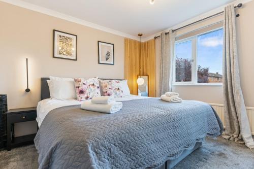 a bedroom with a large bed with two towels on it at 3Bed 2Bath nr Uni HertsHatfield in North Mimms