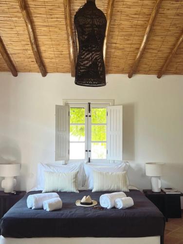 a bedroom with a large bed with hats and towels at Casa das Ameixas in Moncarapacho
