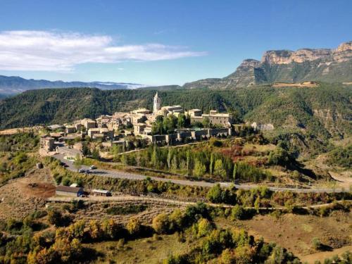 a village on a hill with mountains in the background at Rustic Mountain Retreat in La Puebla de Roda
