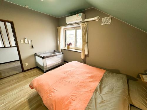a bedroom with a bed and a window with a air conditioner at MATSUNE 松寧 6min walk to Noboribetsu st in Noboribetsu