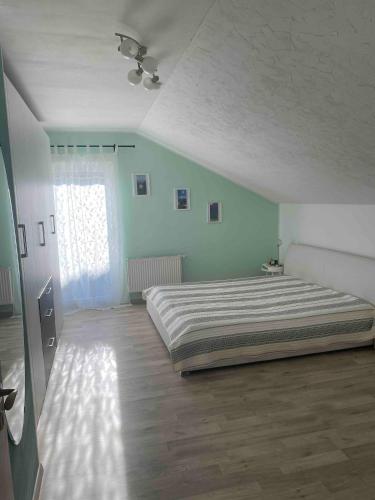 a bedroom with a large bed and a window at Ferienwohnung Alpenblick in Wasserburg am Inn