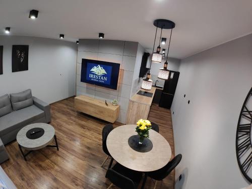 a living room with a table and a couch at Apartament IRESTAN - Komfortowy wypoczynek w sercu Karkonoszy in Jelenia Góra
