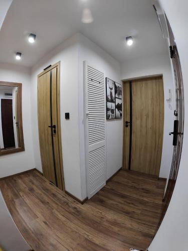 a hallway with a round mirror and a door at Apartament IRESTAN - Komfortowy wypoczynek w sercu Karkonoszy in Jelenia Góra