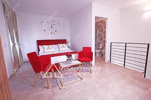 Zimmer mit einem Bett und zwei roten Stühlen in der Unterkunft GD Case Vacanza - Suite del Conte - Salento Luxury Private Suite Idromassaggio in Specchia