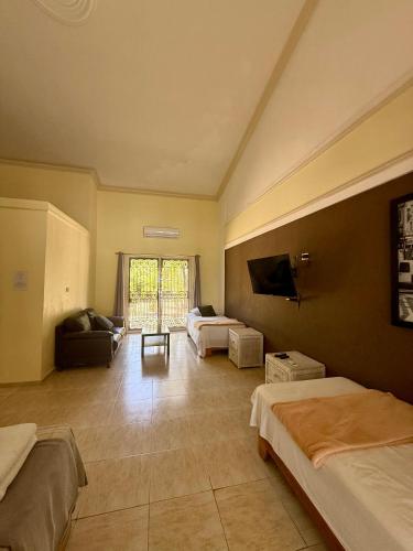 a large room with two beds and a tv at Hotel Al Mare in Santa Cruz de Barahona