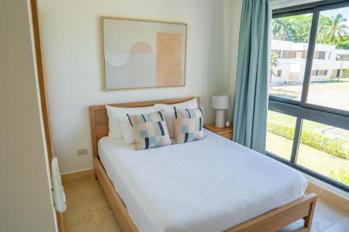 a bedroom with a bed with pillows and a window at Xeliter Green One Playa Dorada in San Felipe de Puerto Plata
