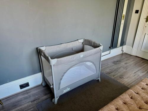 a baby crib in the corner of a room at Immanuel House - Modern Luxury Victorian Home 1872 - Free Parking & SuperFast Fibre Optic WiFi in Edinburgh