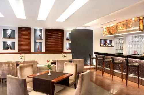 a restaurant with a bar with chairs and a table at Blanca Hotel in Izmir