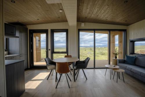 a living room with a table and chairs and a couch at Blue View Cabins in Reykholt
