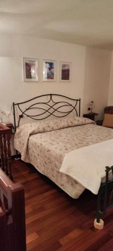 a bedroom with a large bed with a wooden floor at La Casetta Valdonica La Spezia in Calice al Cornoviglio