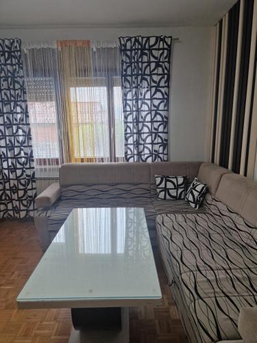 a living room with a couch and a glass table at apartma-sobe Lejla in Vipava