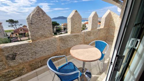 a balcony with a table and chairs and a view of the ocean at Hotel Miramar Playa America Nigran in Nigrán