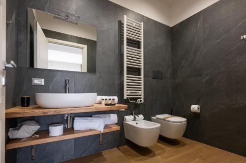 a bathroom with a sink and a toilet at Le Absidi luxury rooms and suites in Sciacca
