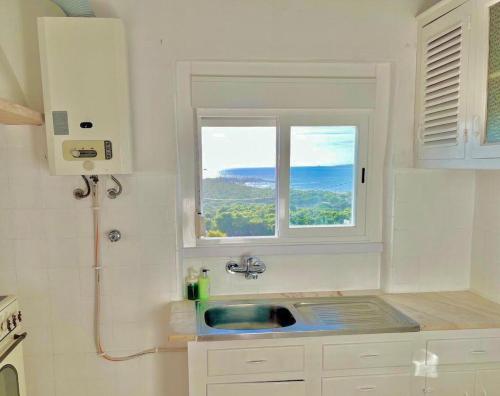 eine Küche mit Spüle und Fenster in der Unterkunft CASA n'A COSTA in Trafaria