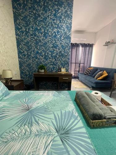 a bedroom with a bed and a blue wall at Hermoso Departamento Céntrico con piscina in Trinidad