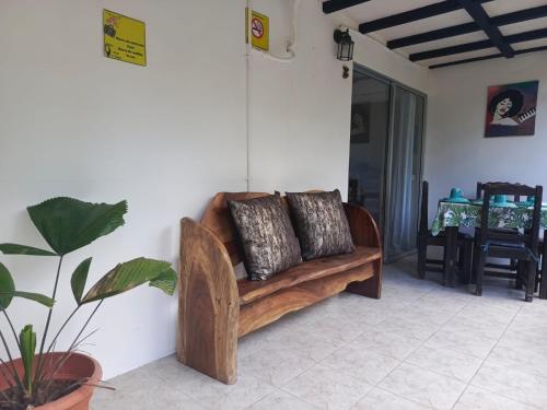 a wooden couch with two pillows on a wall at Hotel Boutique D Angelo in Manzanillo