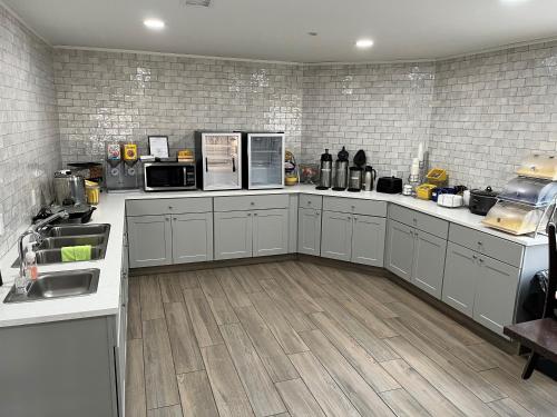a large kitchen with white counters and appliances at Days Inn by Wyndham Liberal KS in Liberal