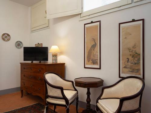 a living room with two chairs and a tv and a dresser at Borgia di Firenze in Florence