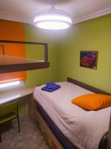 a small bedroom with a bed and a desk at Casa Manuel in Alcañiz