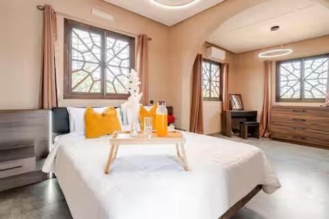 a large bedroom with a large white bed with yellow pillows at villa a marrakech with warm pool in Marrakech