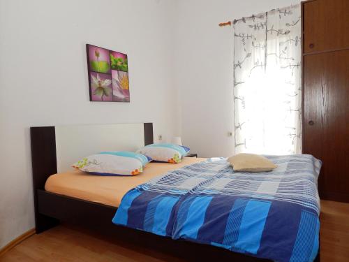 a bed with two pillows on it in a bedroom at Apartments Paro in Pag