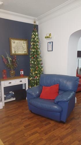 a blue couch in a living room with a christmas tree at Large countryside home in Tow Law