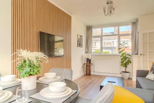 a living room with a table and a tv at Cozy House in Manchester