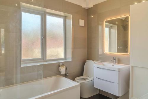 a bathroom with a tub and a toilet and a sink at Cozy House in Manchester