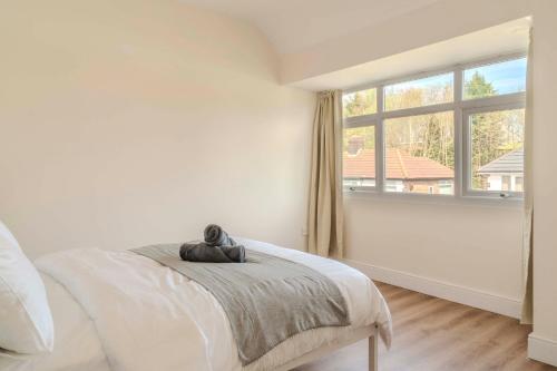 a white bedroom with a bed and a window at Cozy House in Manchester
