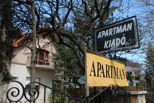 a sign for a restaurant in front of a building at Vicze Apartmanház in Siófok
