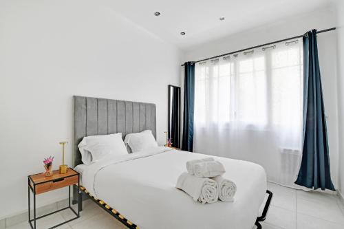 une chambre avec un grand lit blanc avec des serviettes dessus dans l'établissement Cozy & Spacious Apartment - 1BDR-4P - Gare de Lyon, à Paris