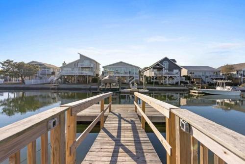 a dock with houses and boats in the water at Pug Life - Walk to the Ocean in Ocean Isle Beach