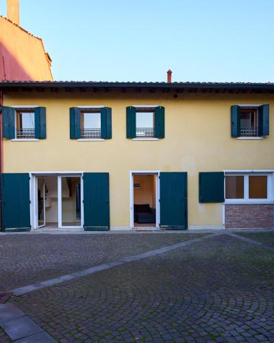 a yellow building with green shutters on it at HOUSE RIVA casa VENEZIA - Dolo in Dolo