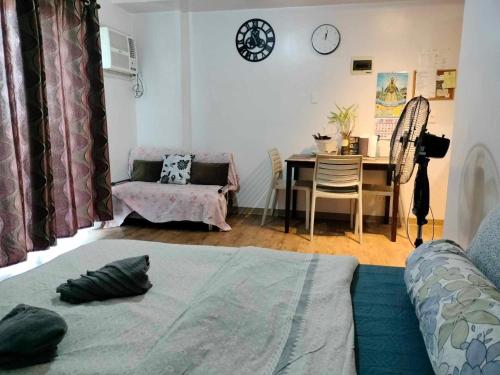Sala de estar con cama y mesa con silla en Anya and Carl's Comfy, en Mactan