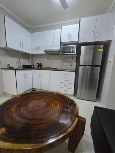a kitchen with a wooden table in the middle of it at Doctors Apartment in Suva