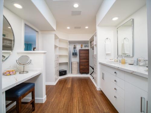 ein Badezimmer mit weißen Schränken und einem Spiegel in der Unterkunft Remodeled Beachfront Estate, Magnificent Mango Surf in Kihei