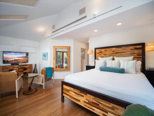 ein Schlafzimmer mit einem großen Bett und einem Schreibtisch in der Unterkunft Remodeled Beachfront Estate, Magnificent Mango Surf in Kihei