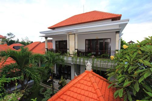 a small house with an orange roof and some trees at Gatra Ubud Inn in Ubud