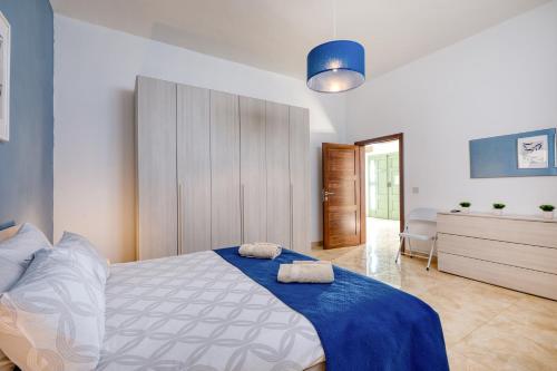 a bedroom with a bed with two towels on it at Spacious, Bright, Valley & Sea View Maisonette in Xagħra