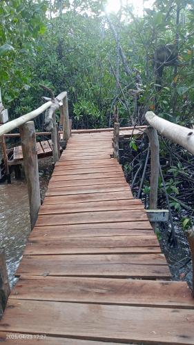a wooden bridge over a body of water at OMBAR Homestay in Minyaifuin