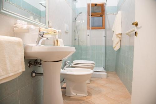 a bathroom with a toilet and a sink and a shower at Soraya - Suites & Apartments in Palau