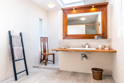 ein Bad mit einem Waschbecken und einem Spiegel in der Unterkunft Bunaken Cha Cha Nature Resort in Bunaken