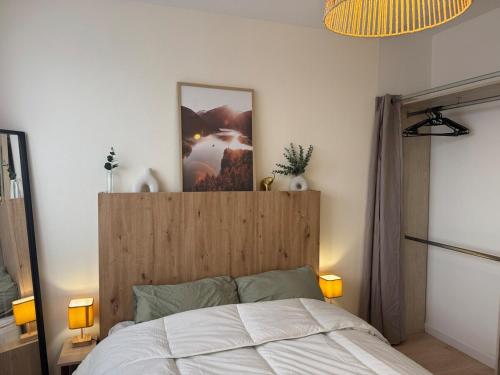 Appt Ideal groupes, prox Eurexpo في سانت-بريست: غرفة نوم مع سرير مع لوح خشبي للرأس