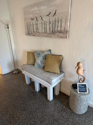 a bench in a room with a picture of birds at La Mare Fort Lauderdale Airport in Fort Lauderdale
