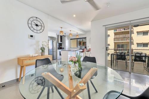 a dining room with a glass table and chairs at Darwin Inner City Oasis 2 Bed Apt in Darwin