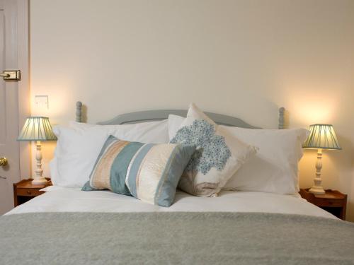 a bedroom with a bed with pillows and two lamps at The Greyhound Inn in Wantage